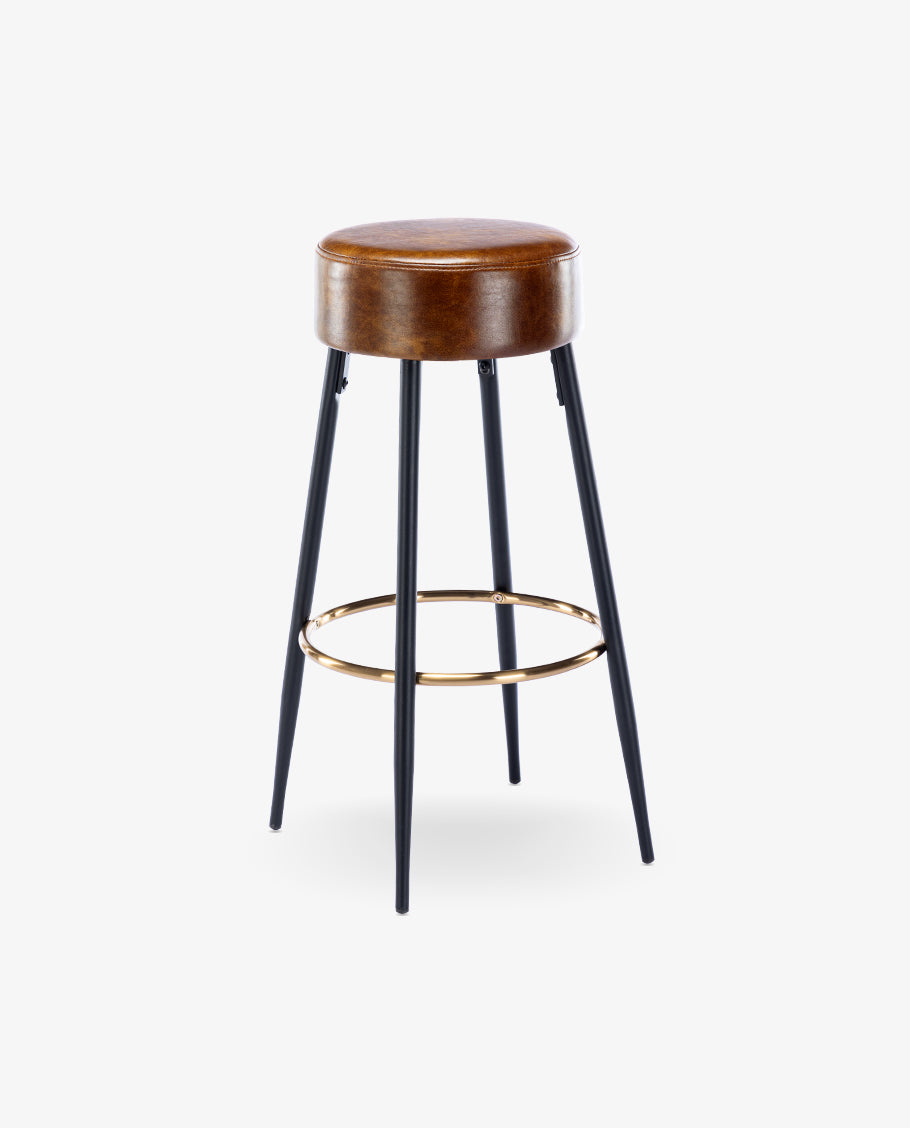 Close-up of the brown leather seat and black metal leg with a gold footrest on bar stool.